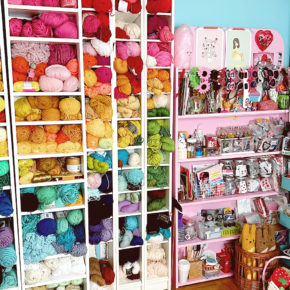 Bookshelves filled with colorful balls of yarn and other craft supplies