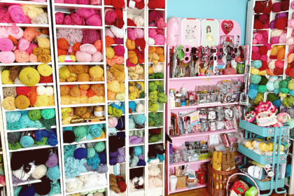 Bookshelves filled with colorful balls of yarn and other craft supplies