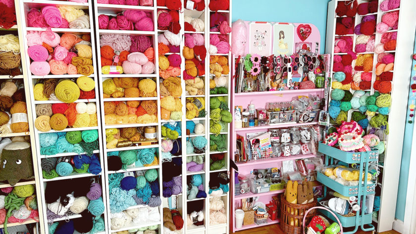Bookshelves filled with colorful balls of yarn and other craft supplies