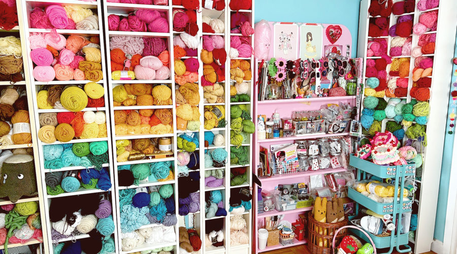 Bookshelves filled with colorful balls of yarn and other craft supplies