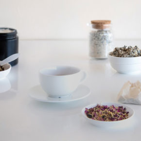 An elegant scattering of bowls and jars of dried botanicals and handmade candles and bath and body products