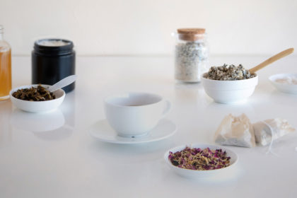 An elegant scattering of bowls and jars of dried botanicals and handmade candles and bath and body products