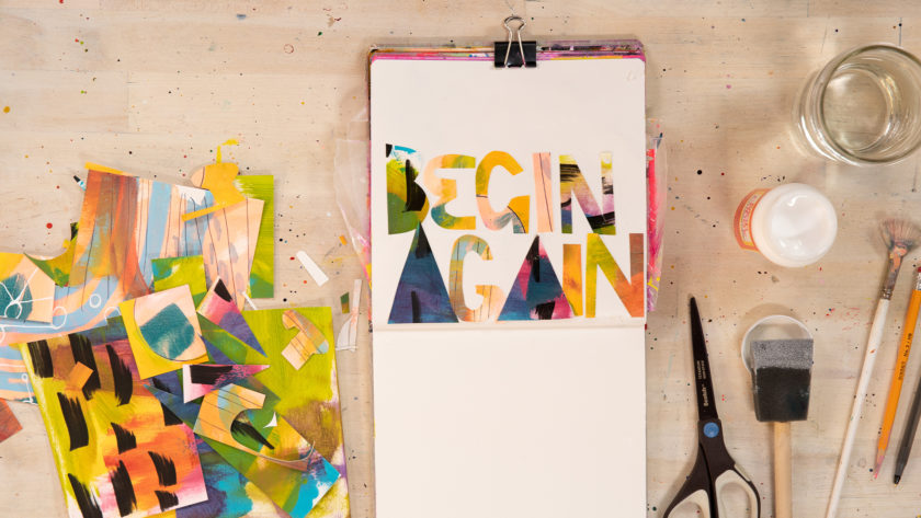 An open sketchbook by abstract painter Abby Houston with painted text that reads "Begin Again"