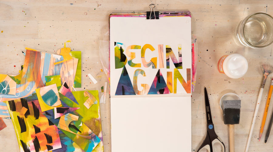 An open sketchbook by abstract painter Abby Houston with painted text that reads "Begin Again"