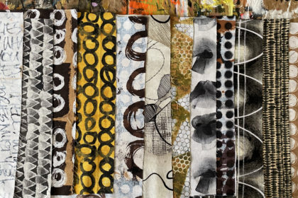 an array of folded fabrics lined up on a table, in black, white, and a some yellow, and bold, hand-painted strokes and patterns, designed by artist e bond