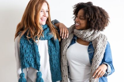 image of 2 women standing next to each other wearing handmade knitted scarves and smiling