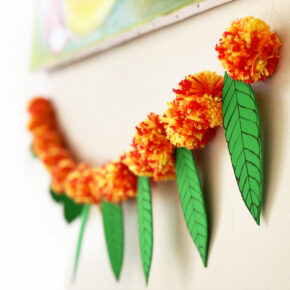 image of torana or garland made of yarn pom poms and craft foram leaves to represent marigolds and mango leaves for Diwali