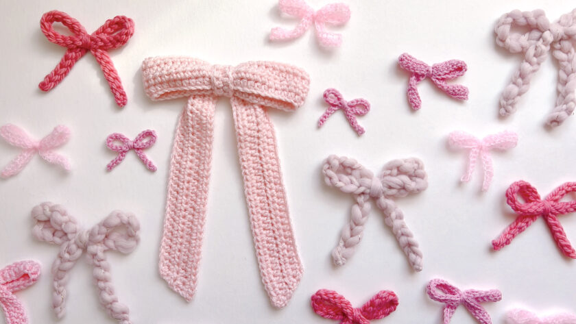 a flat lay of many pink crocheted bows in different shades and sizes and yarns