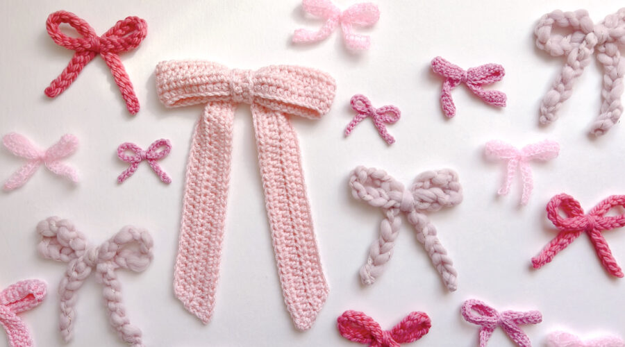 a flat lay of many pink crocheted bows in different shades and sizes and yarns