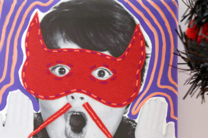image of black and white photo of a child with a surprised face and mixed media felt and embroidered red mask and moustache for halloweenj