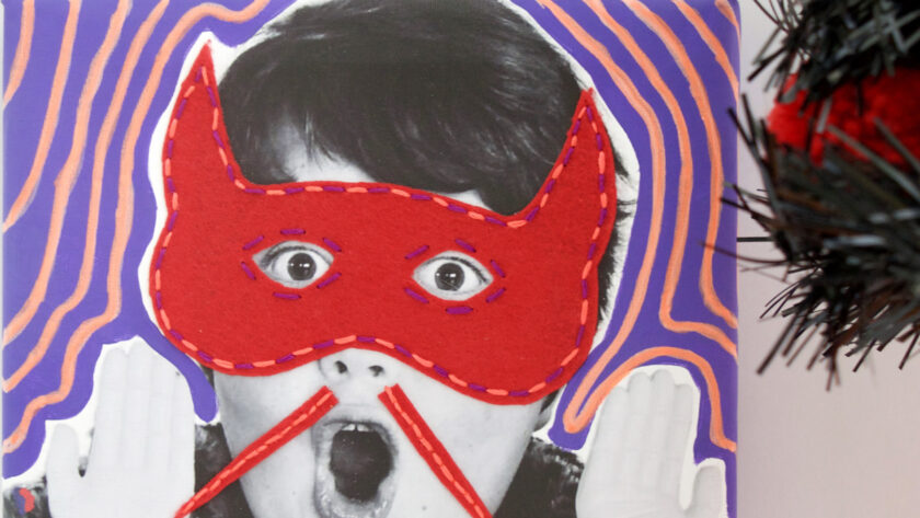 image of black and white photo of a child with a surprised face and mixed media felt and embroidered red mask and moustache for halloweenj